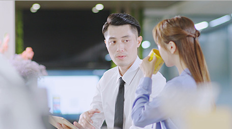 商务西装男女指点微笑近景喝东西实拍