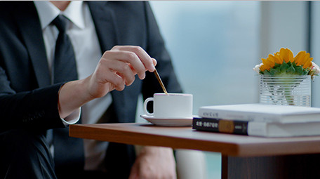 商务西装男室内窗边搅拌咖啡杯休闲实拍