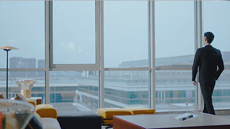 商务西装男气质走到窗边眺望室内实拍