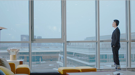 商务西装男气质走到窗边眺望室内实拍