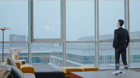 商务西装男气质走到窗边眺望室内实拍