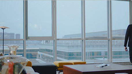 商务西装男气质走到窗边眺望室内实拍