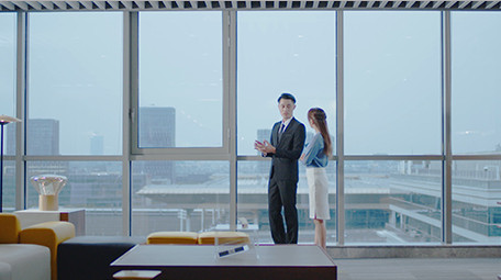 商务室内西装男女窗边指点实拍