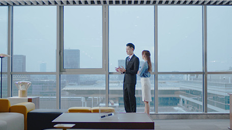 商务室内西装男女窗边指点实拍