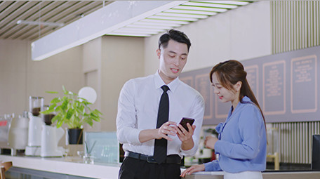 商务男女微笑工作吧台手机室内实拍