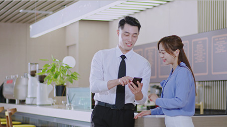 商务男女微笑工作吧台手机室内实拍