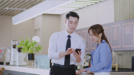 商务男女微笑工作吧台手机室内实拍