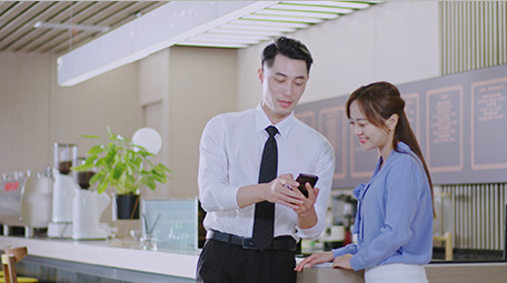 商务男女微笑工作吧台手机室内实拍