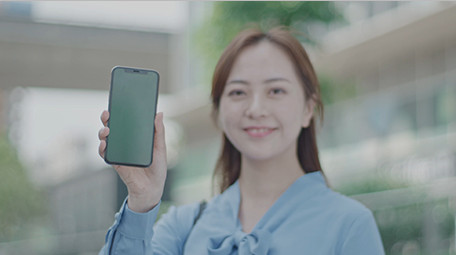 商务女微笑举起手机室外实拍近景