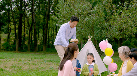 4k户外爸爸端着零食和家人一起分享