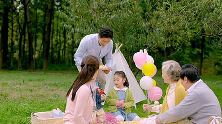 4k户外爸爸端着零食和家人一起分享