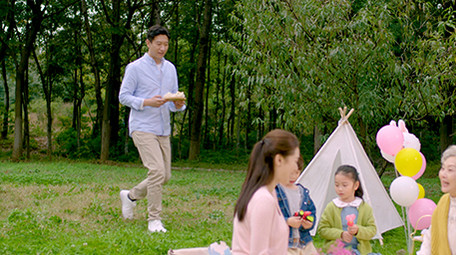 4k户外爸爸端着零食和家人一起分享