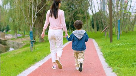 4k妈妈和儿子在公园里散步背影实拍