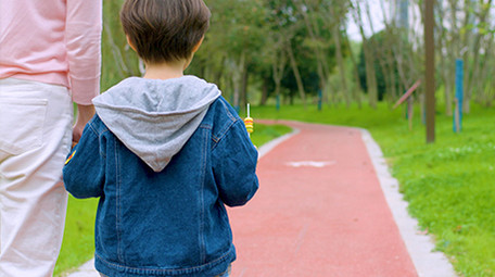 4k妈妈和儿子在公园里散步背影实拍