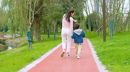 4k妈妈和儿子在公园里散步背影实拍