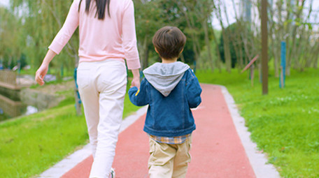 4k妈妈和儿子在公园里散步背影实拍