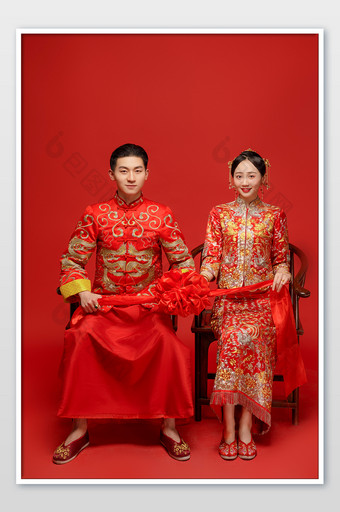 穿着中式传统婚服的新人拿着绣球图片