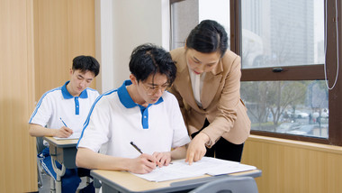 4k学校课堂上老师给学生指导讲解题目
