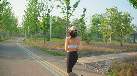 4K实拍阳光下女子在马路上跑步视频素材