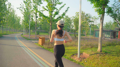 4K实拍阳光下女子在马路上跑步视频素材