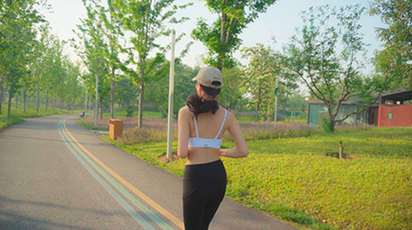 4K实拍阳光下女子在马路上跑步视频素材