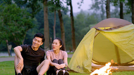 年轻情侣户外野营露营开心交流实拍