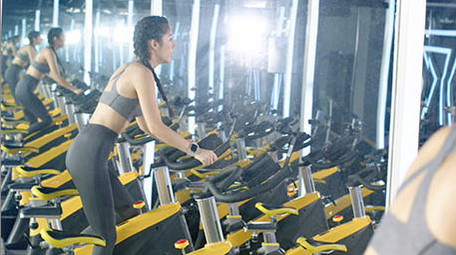 健身房动感单车运动的女子背影实拍