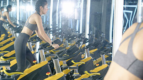 健身房动感单车运动的女子背影实拍