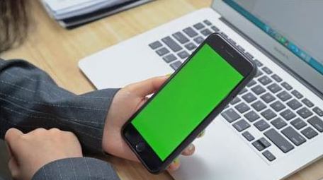商务办公人员观看笔记本电脑手机绿屏实拍