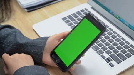 商务办公人员观看笔记本电脑手机绿屏实拍