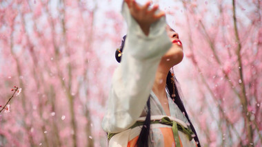 自然实拍汉服美女开心的抓樱花花瓣