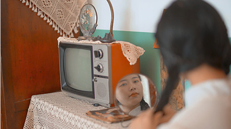 人像美女六七十年代女性对着镜子梳妆扎鞭子