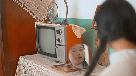 人像美女六七十年代女性对着镜子梳妆扎鞭子