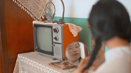 人像美女六七十年代女性对着镜子梳妆扎鞭子