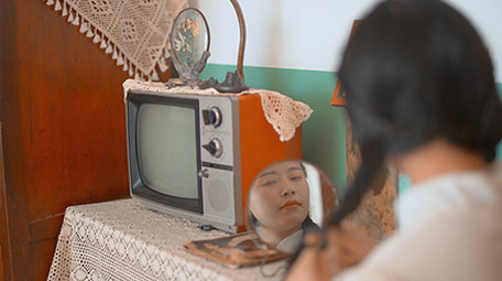 人像美女六七十年代女性对着镜子梳妆扎鞭子