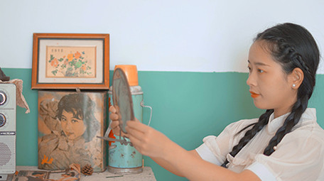 人像六七十年代女性对着镜子梳妆扎鞭子