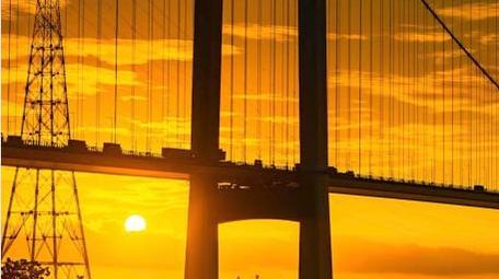 日出朝霞大桥太阳从大桥钻出延时