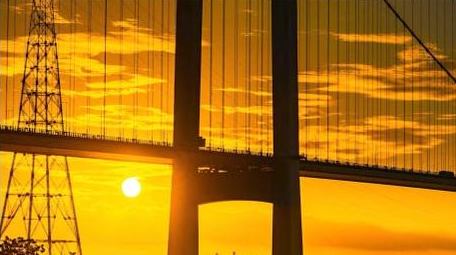 日出朝霞大桥太阳从大桥钻出延时