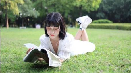 草地上阅读的少女唯美实拍4k