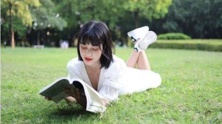 草地上阅读的少女唯美实拍4k