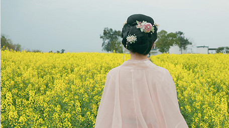 春季汉服美女在菜花田背影实拍