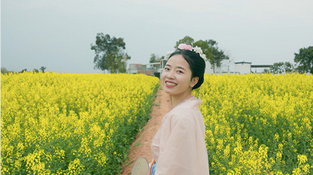 春季汉服美女在菜花田背影实拍