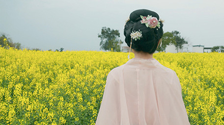 春季汉服美女在菜花田背影实拍