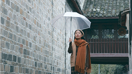 东方人像女孩撑伞漫步雨中实拍
