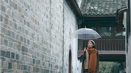 东方人像女孩撑伞漫步雨中实拍