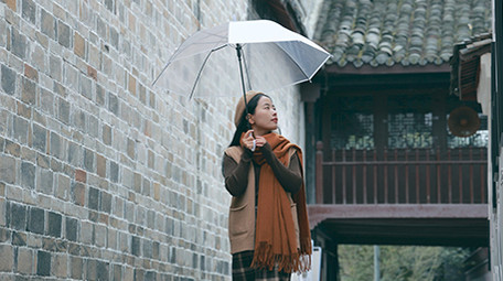 东方人像女孩撑伞漫步雨中实拍