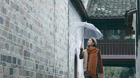 东方人像女孩撑伞漫步雨中实拍