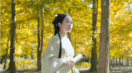 唯美汉服美女行走在银杏树中实拍