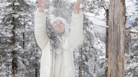 东方人像女孩雪地开心打雪仗实拍
