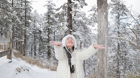 东方人像女孩雪地开心打雪仗实拍